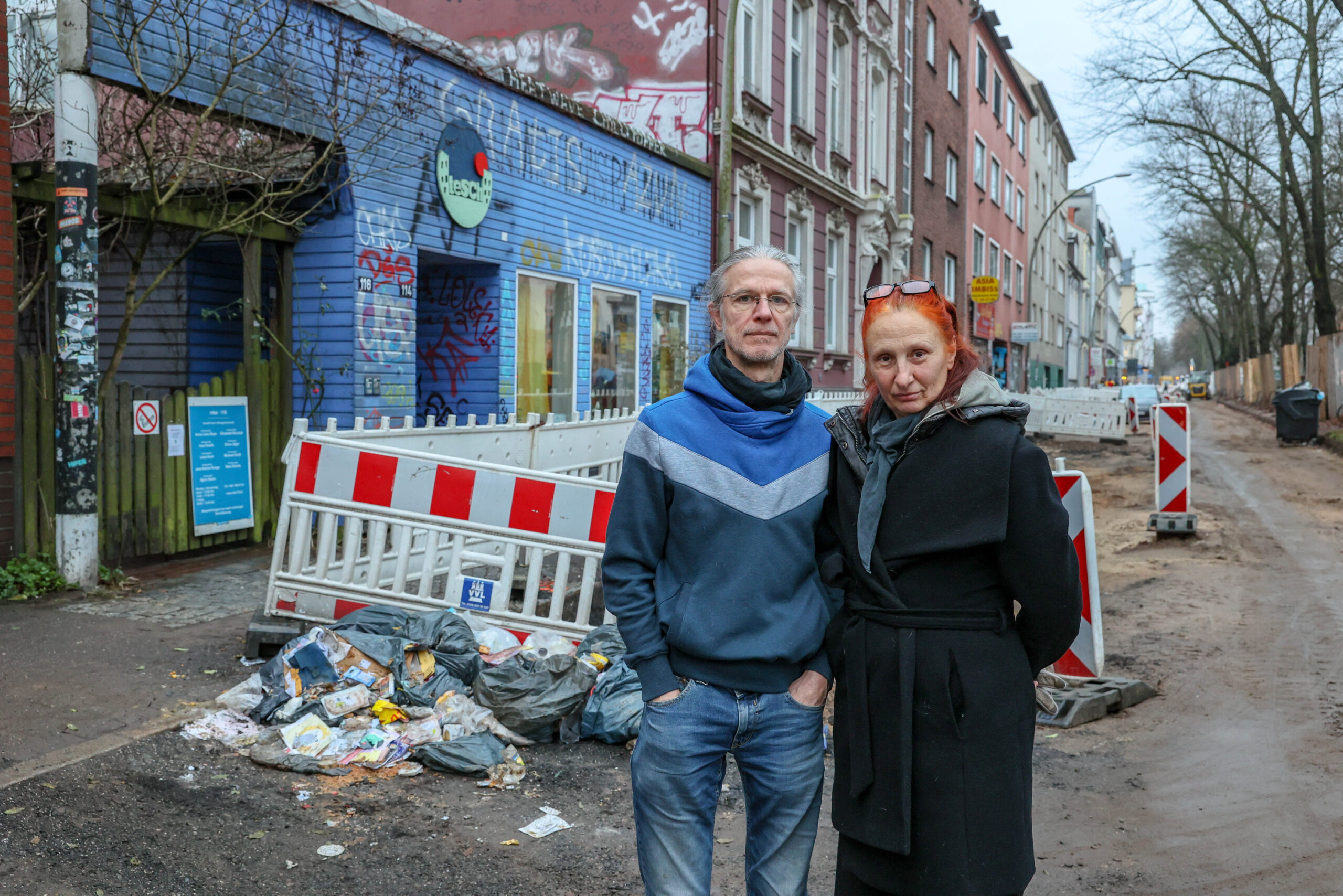 Gunter und Lisa Schmidt stehen vor einem Müllhaufen an der Max-Brauer-Allee.