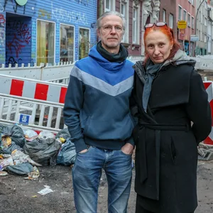 Gunter und Lisa Schmidt stehen vor einem Müllhaufen an der Max-Brauer-Allee.