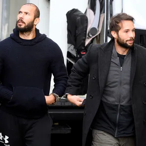 Andrew Tate und sein Bruder Tristan werden von Polizisten zum Gericht in Bukarest gebracht.