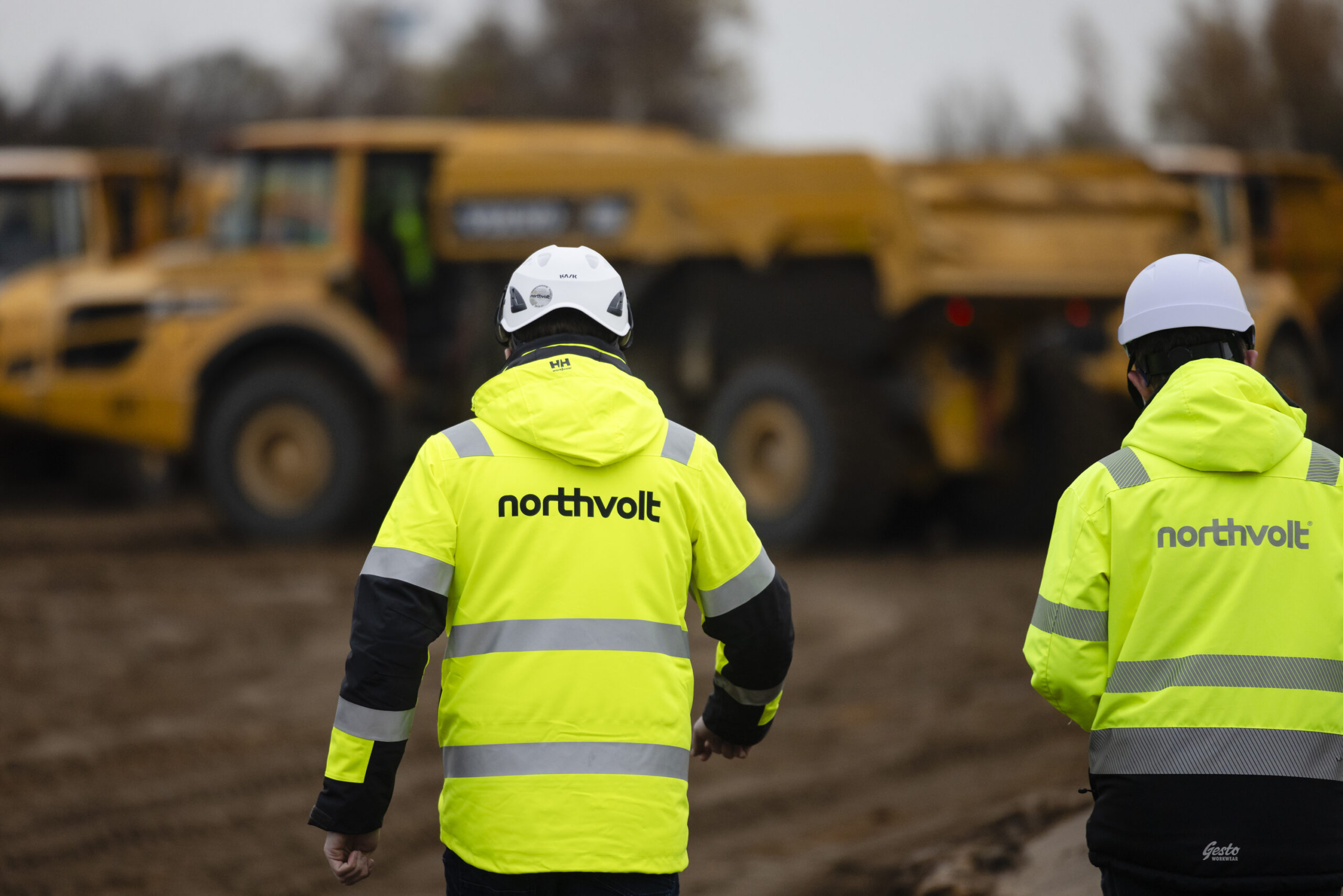 Zwei Mitarbeiter der Firma „Northvolt“ gehen über die Baustelle in Heide.