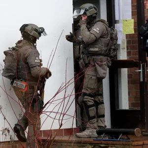 Einsatzkräfte der Polizei dringen in ein Haus einer Kirchengemeinde in Schwerin ein