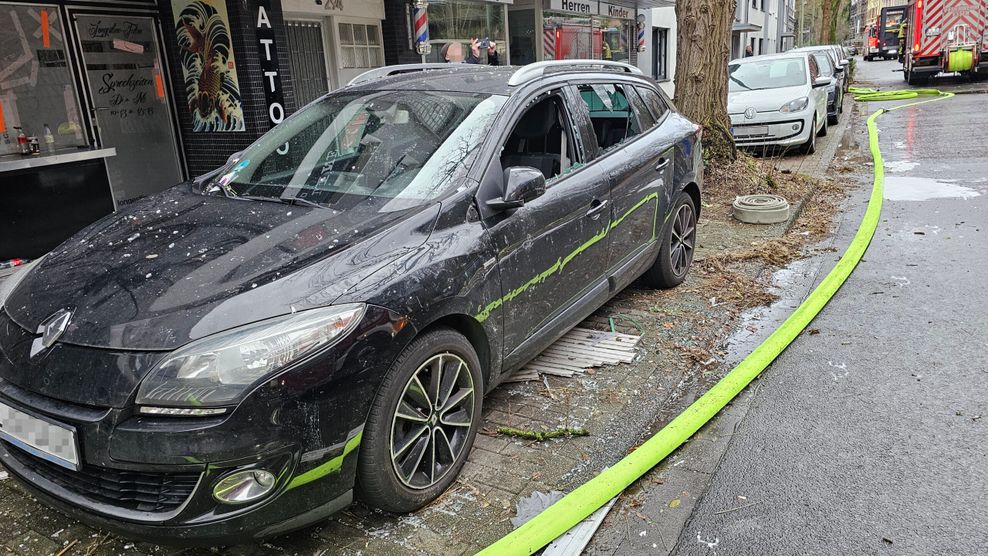 Ein beschädigtes Autos steht nach der Explosion auf der Straße.