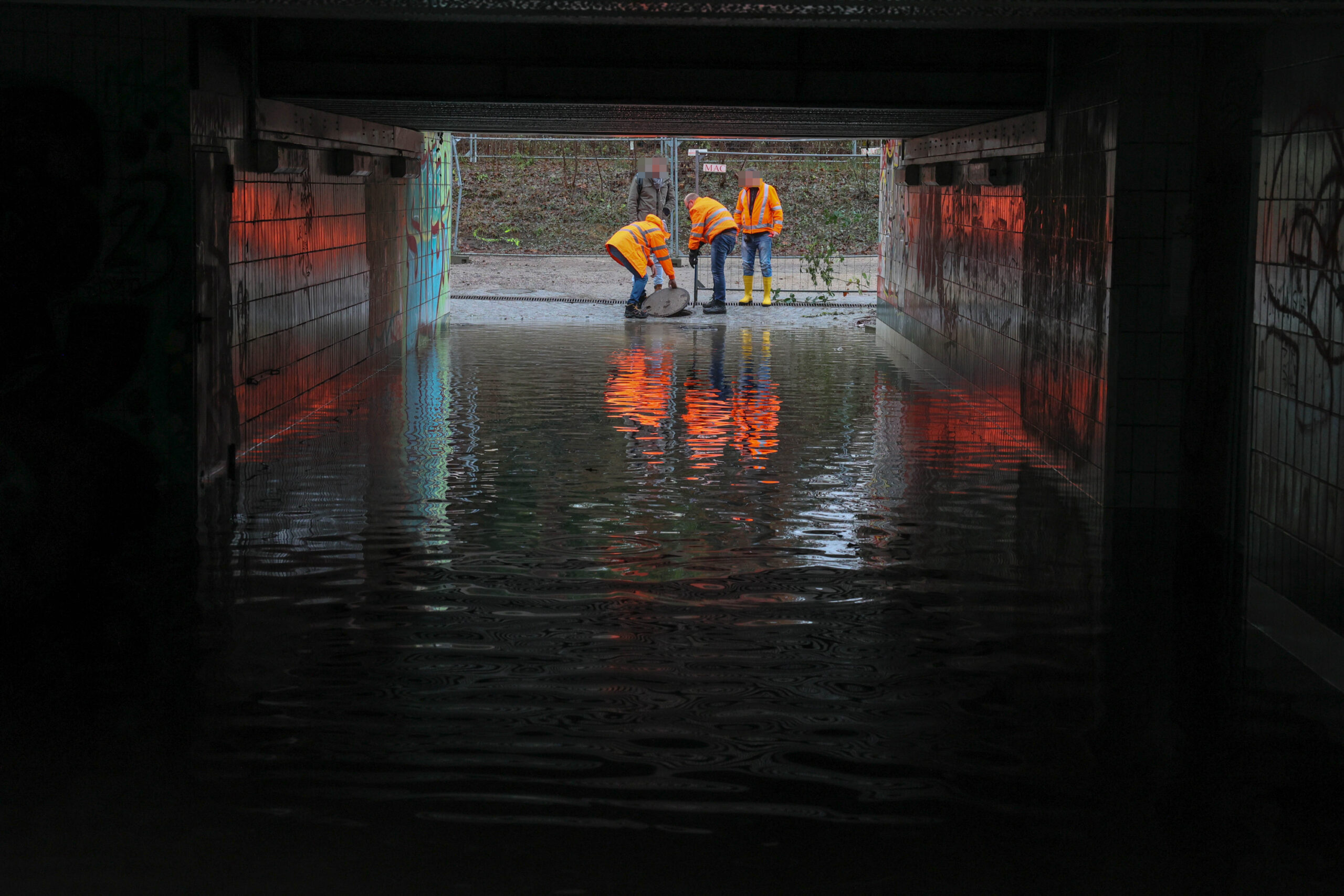 Mitarbeiter der Deutschen Bahn an der Unterführung in Marienthal, die seit Wochen unter Wasser steht.