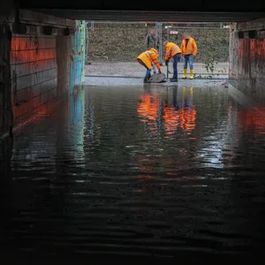Mitarbeiter der Deutschen Bahn an der Unterführung in Marienthal, die seit Wochen unter Wasser steht.