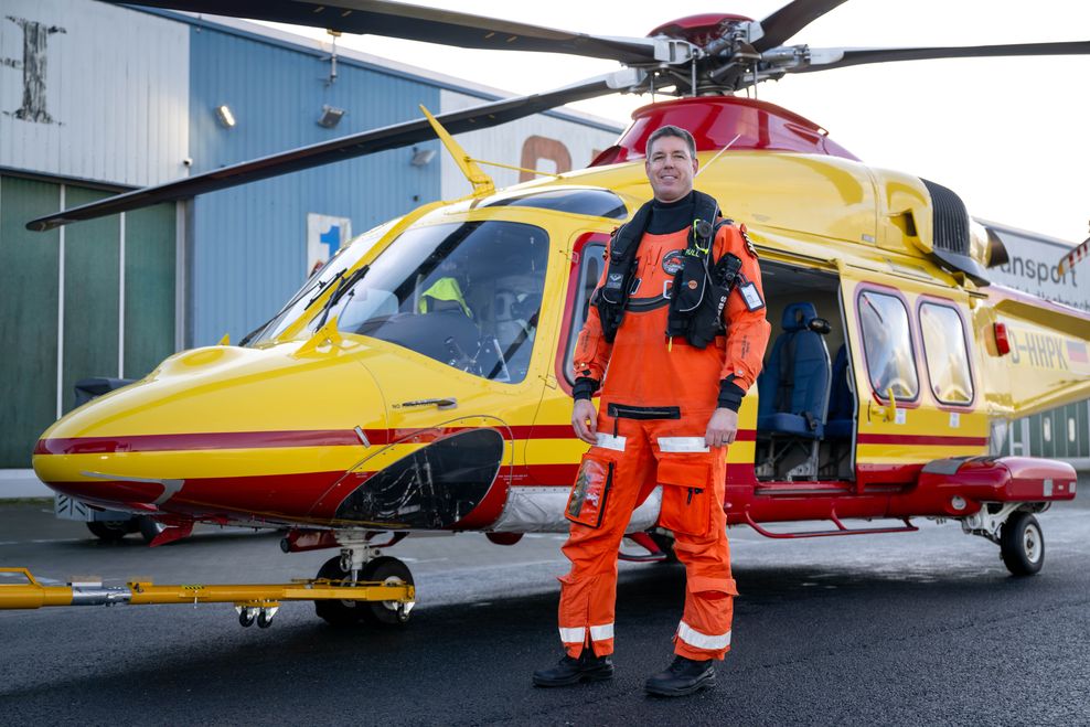 Pilot Falko Baguhl steht vor einem Helikopter des Emder Unternehmens Heliservice.