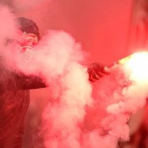 Ein St. Pauli Fan mit Sturmhaube und Pyrotechnik in der Hand