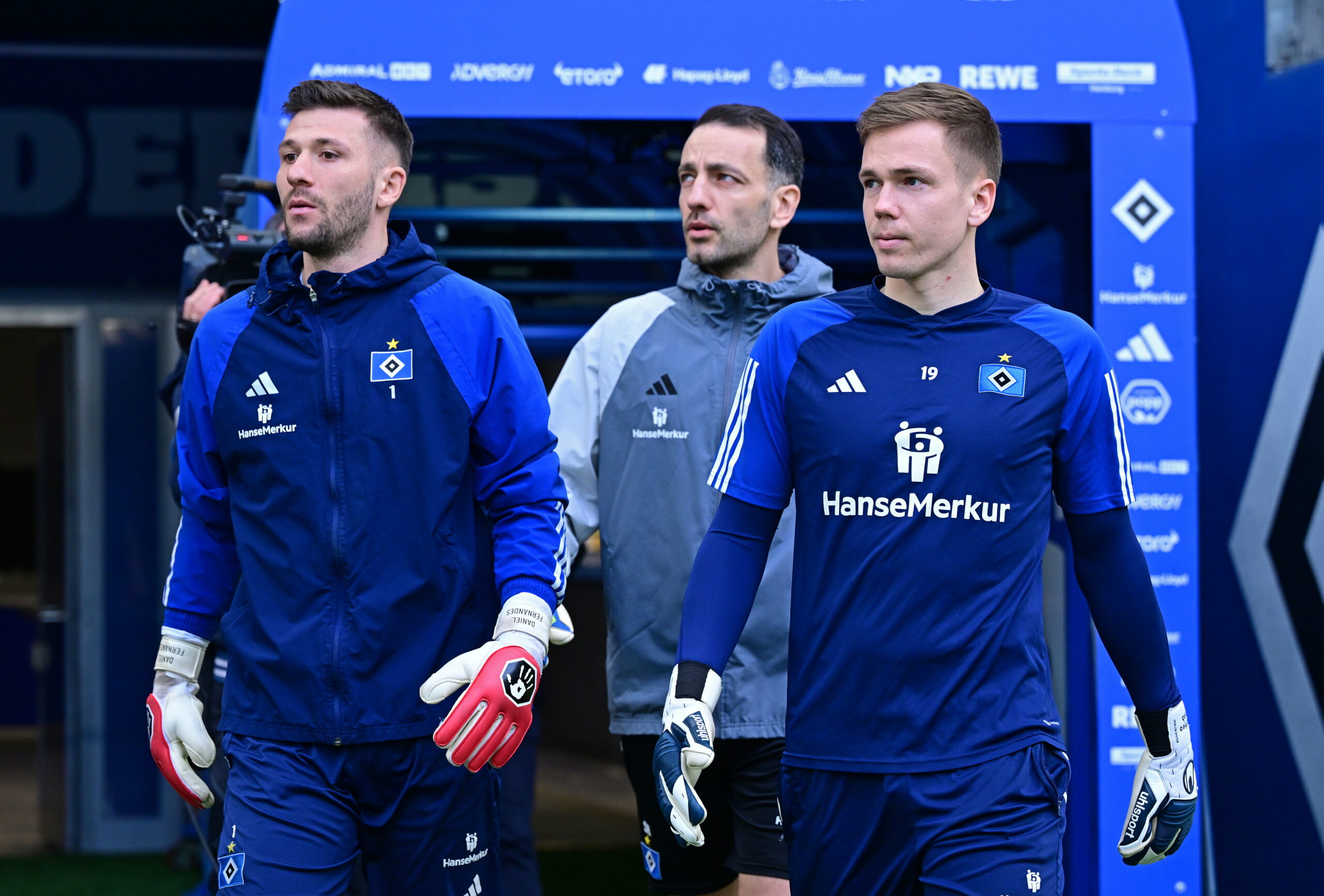 Daniel Heuer Fernandes, Torwarttrainer Sven Höh und Matheo Raab (v.l.) laufen zum Warmmachen ins Stadion ein.