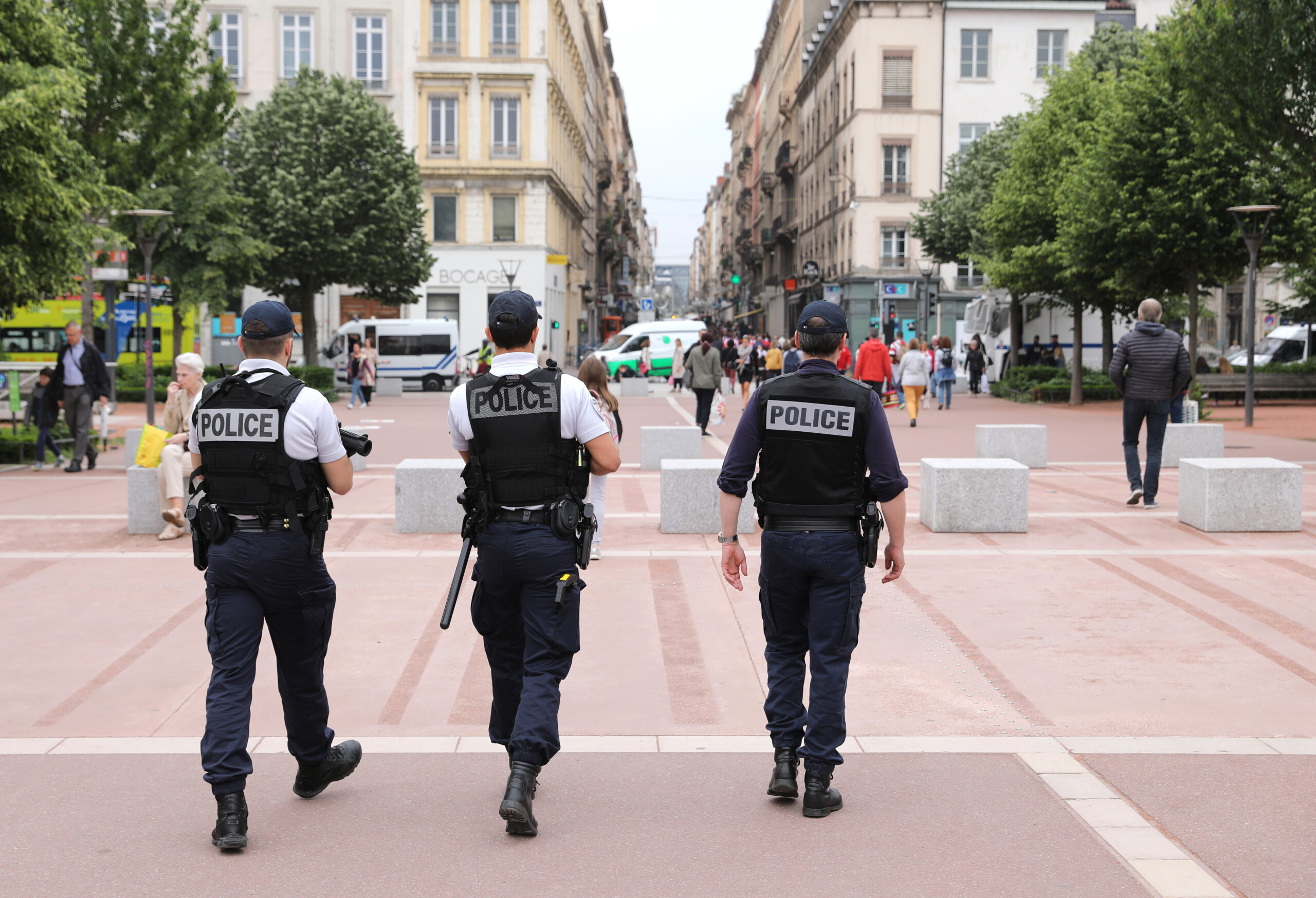 Drei französische Polizisten laufen auf einem Platz
