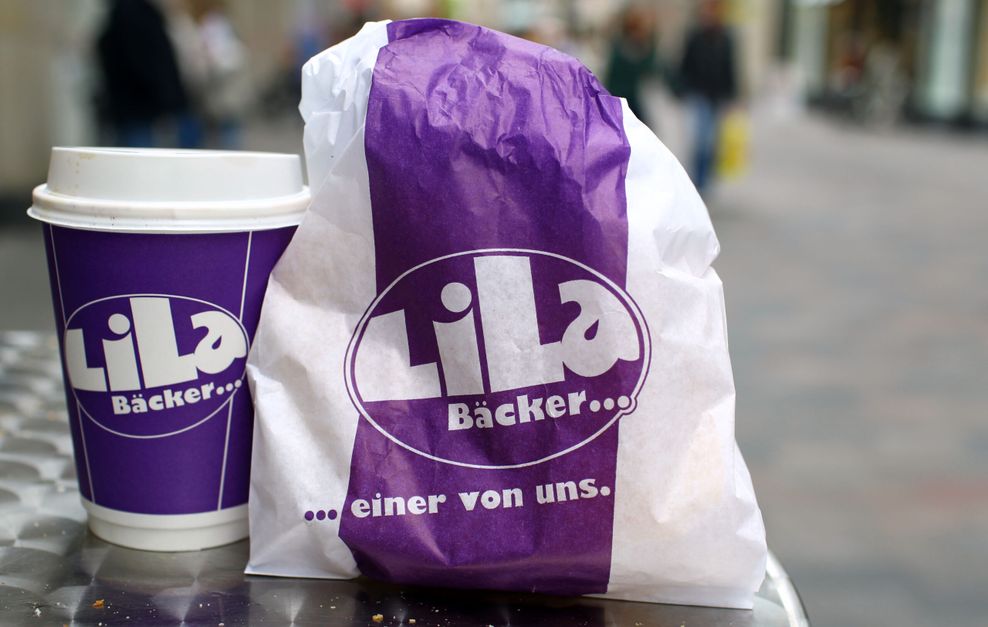 Eine Brötchentüte sowie ein Kaffeebecher der Bäckereikette „Lila Bäcker“. (Symbolbild)