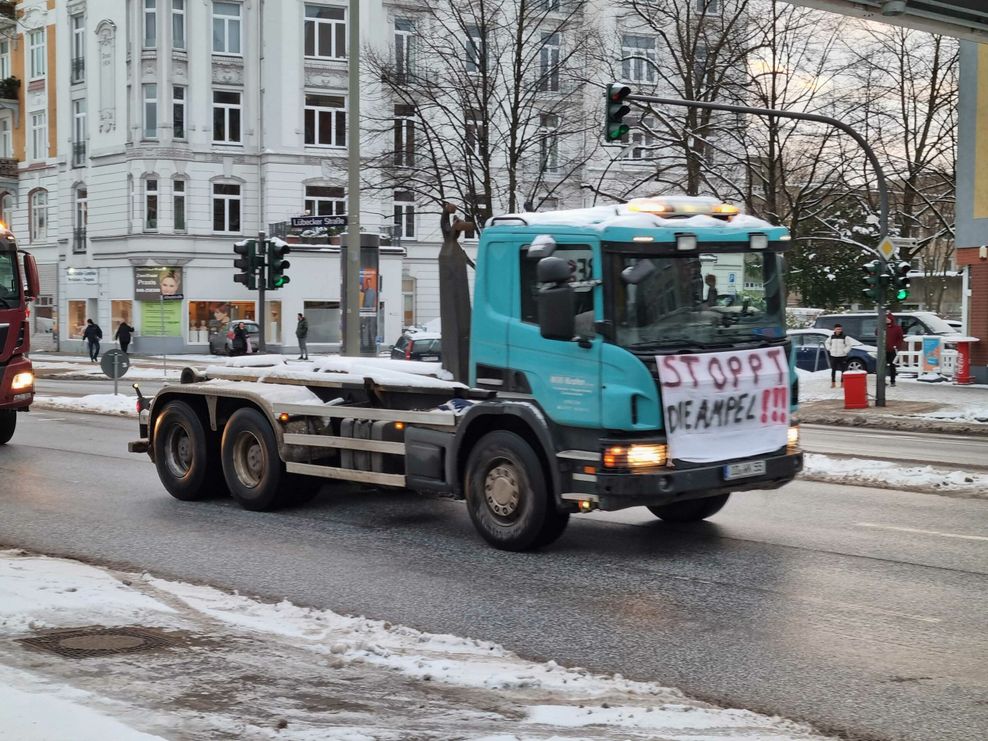 Ein Lkw, der an einem Protestzug teilnimmt. Auf einem Plakat steht „Stoppt die Ampel“.