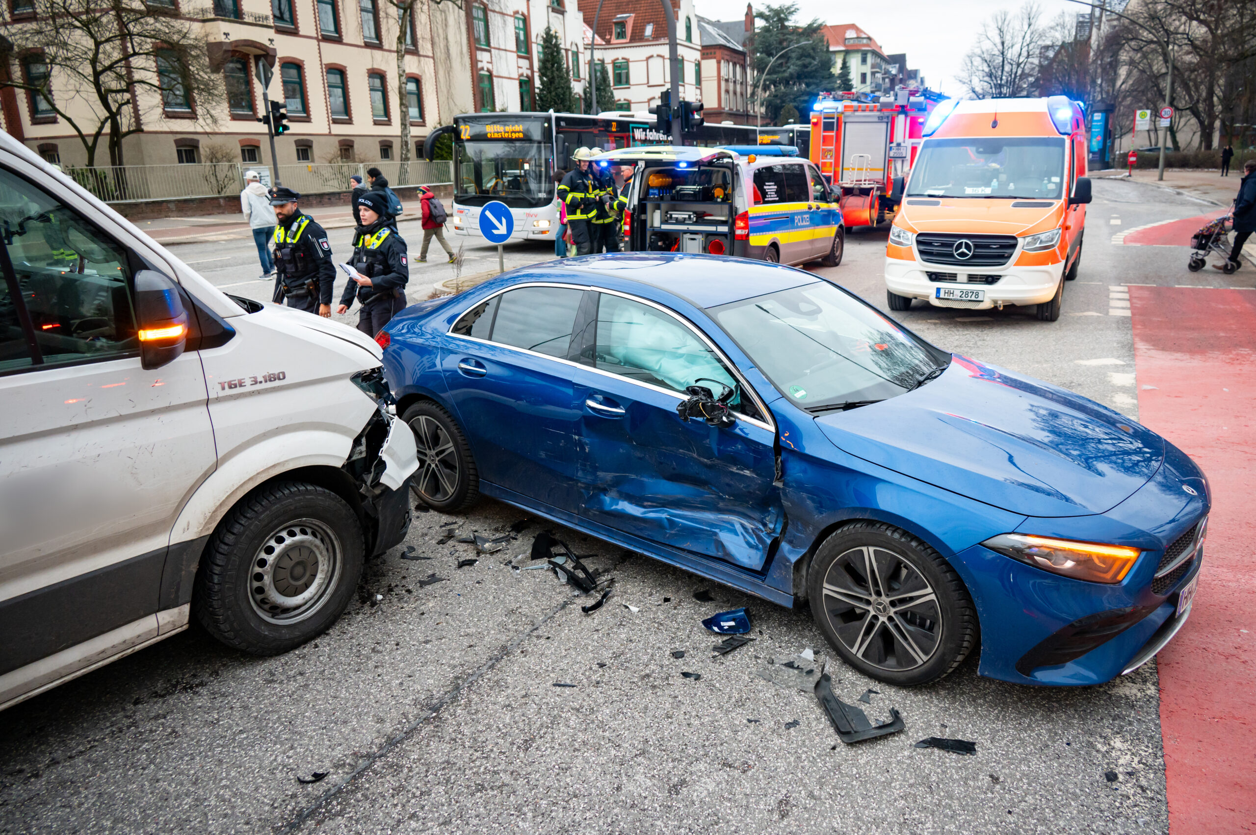Ein an der Seite stark beschädigter blauer Mercedes und ein Transporter