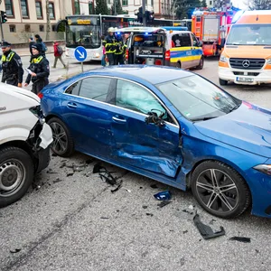 Ein an der Seite stark beschädigter blauer Mercedes und ein Transporter