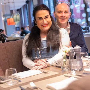 Bianca und Wolfgang Vollheide sitzen in ihrem Restaurant und lächeln in die Kamera