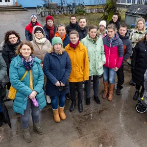 Gruppe von Eltern vor einem blauen Gebäude