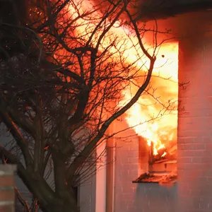 Flammen schlagen aus einem Fenster im Erdgeschoss des Hauses in Itzehoe.