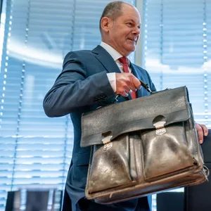 Scholz hat Tasche in der Hand