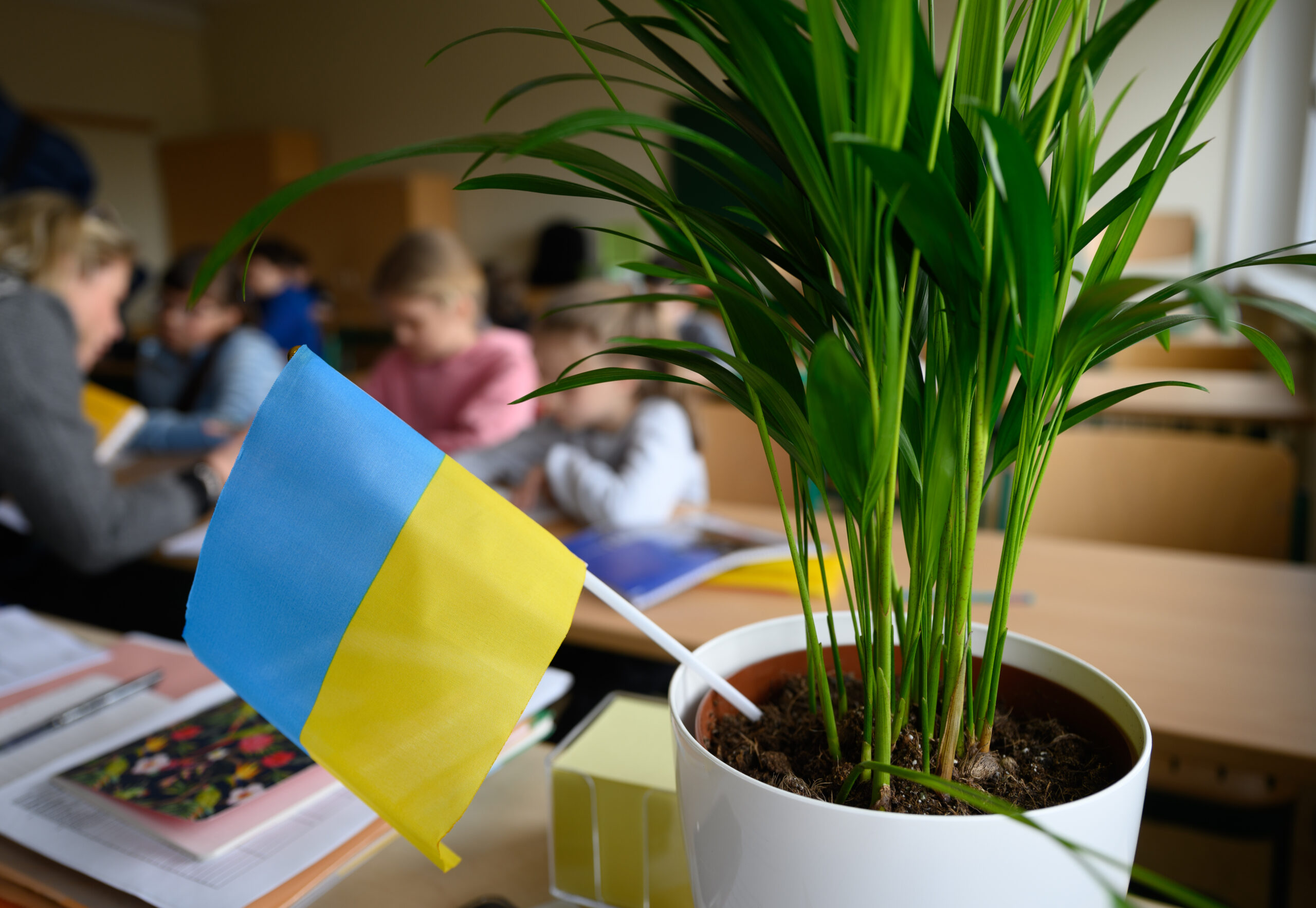 Schulklasse mit ukrainischer Flagge im Vordergrund