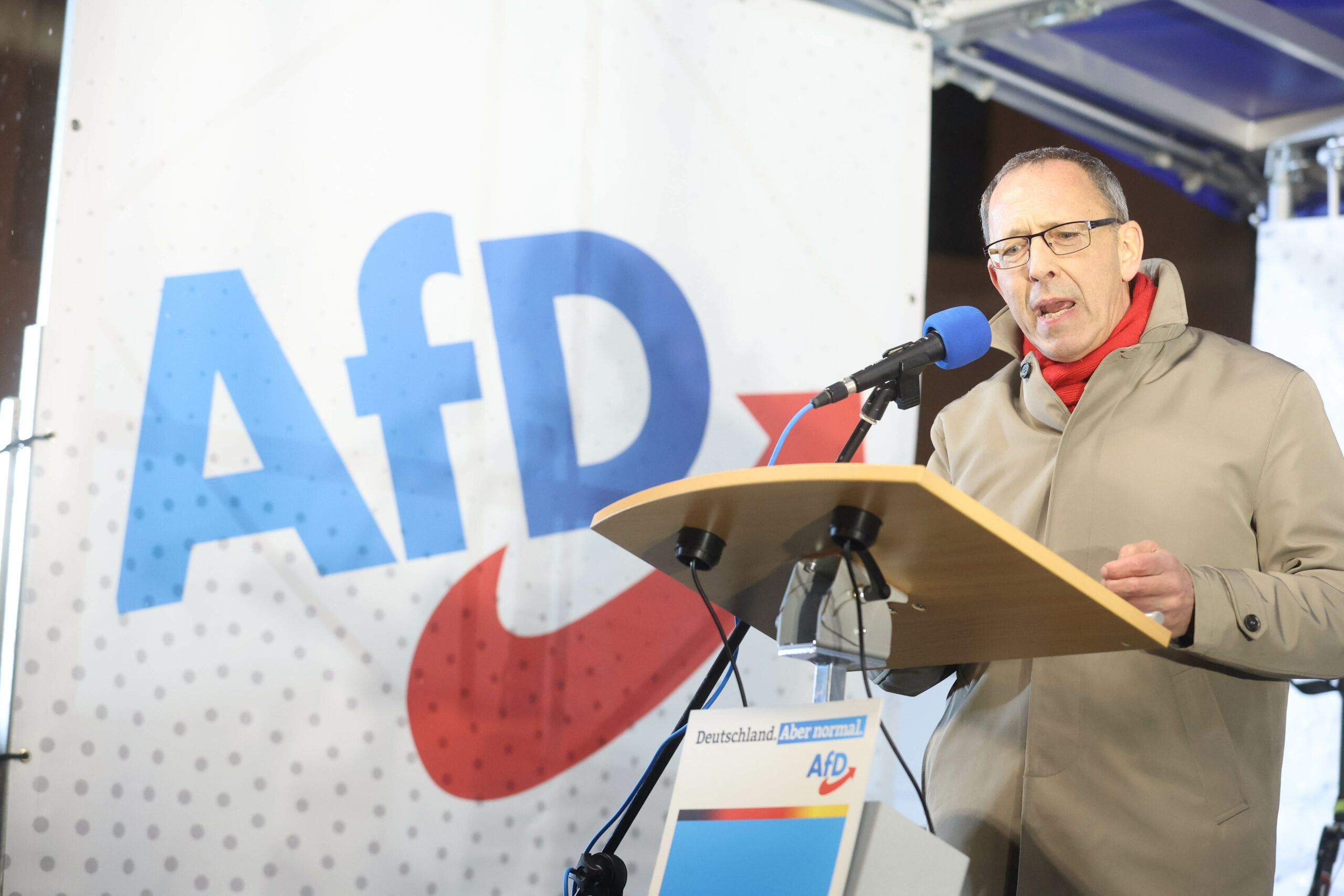 Jörg Urban, AfD-Vorsitzender in Sachsen, spricht bei einer Kundgebung, links ist das Parteilogo zu sehen. (Archivbild von 2022)