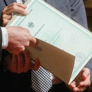 Eine Einbürgerungsurkunde der Bundesrepublik Deutschland wird bei einem Festakt übergeben. (Symbolbild)