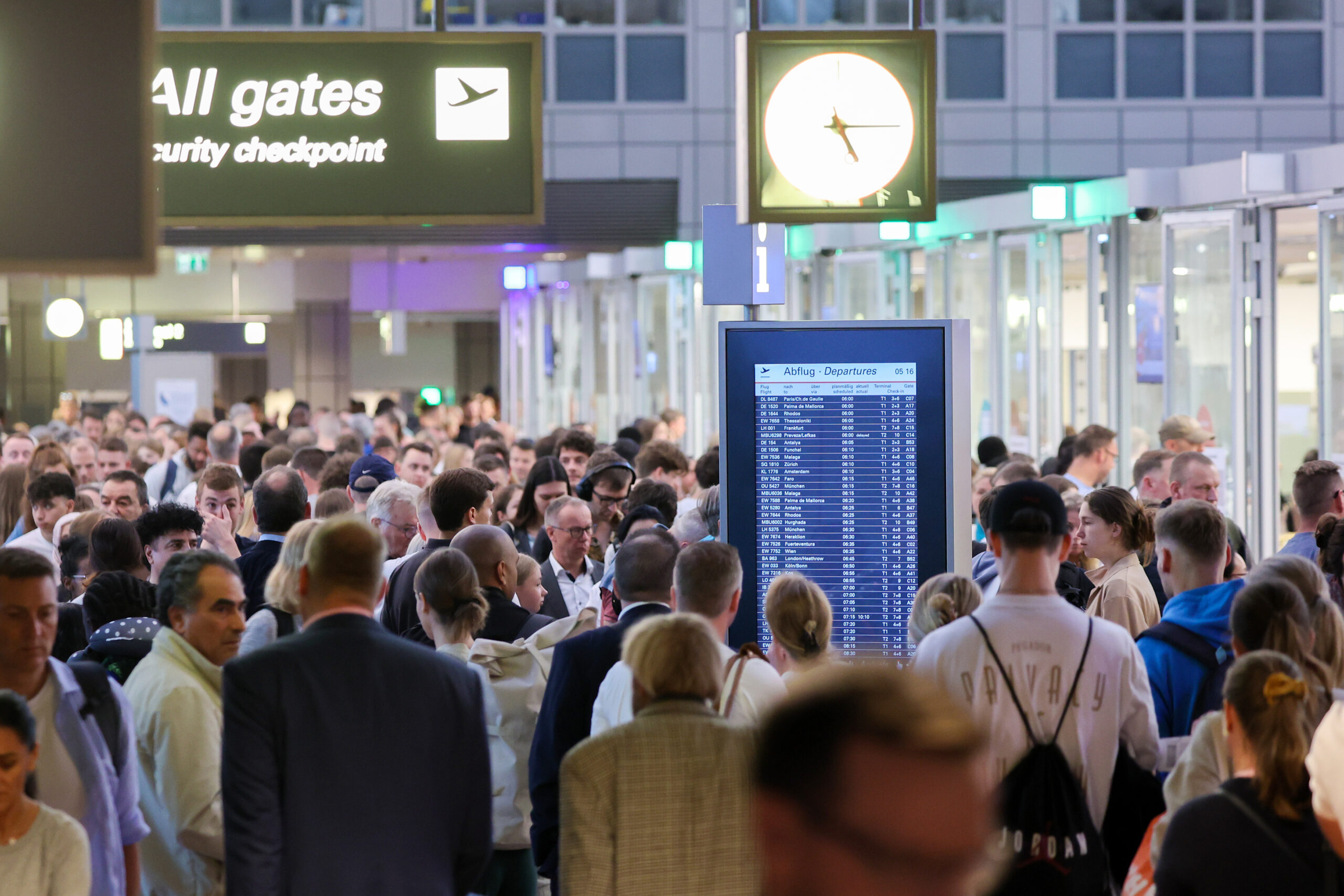 Reisende stehen in Warteschlangen an der Sicherheitskontrolle am Flughafen Hamburg. (Archivbild)