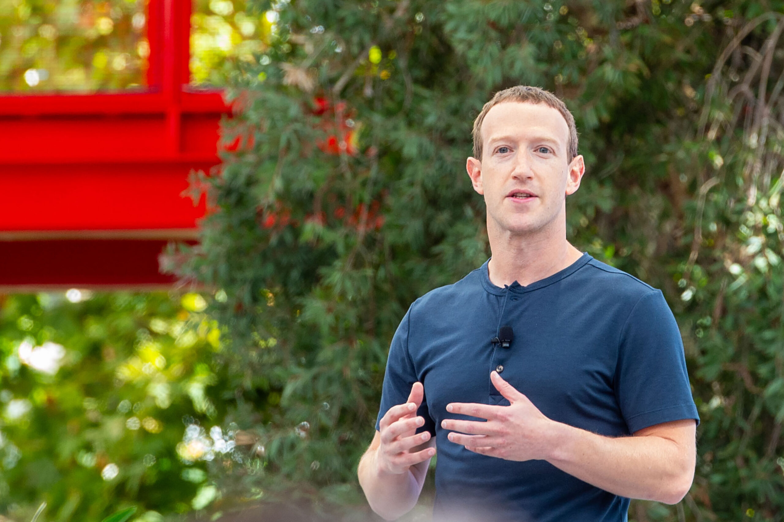 Facebook-Chef Mark Zuckerberg steht draußen im Grünen vor einen Busch.