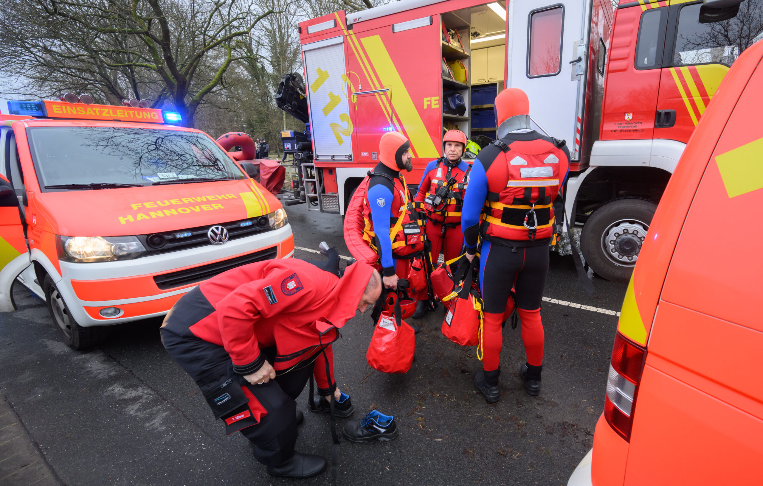 Einsatzkräfte der Wasserrettung der Feuerwehr Hannover stehen bei einem Einsatz auf einer überfluteten Straße zwischen Hannover und Hemmingen.