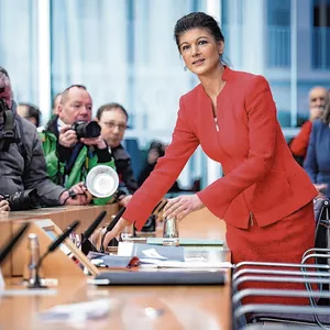 Sahra Wagenknecht im roten Kostüm vor Pressefotografen