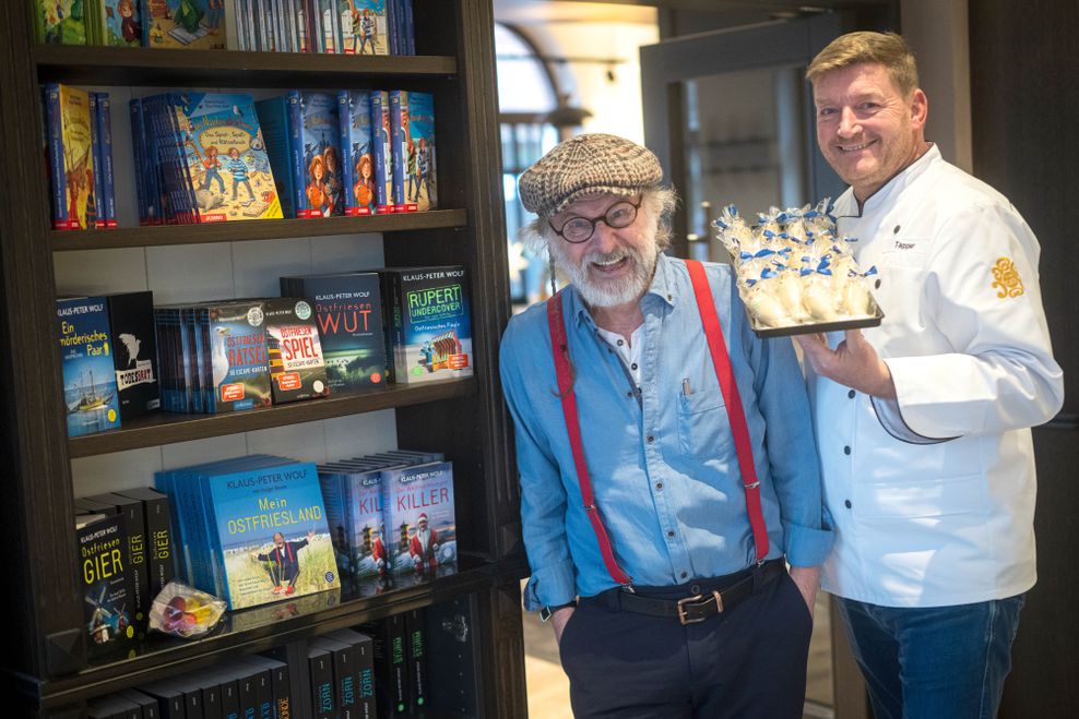 Klaus-Peter Wolf (l.) und Jörg Tapper, Besitzer vom Café ten Cate, stehen vor der Bücherwand im Café