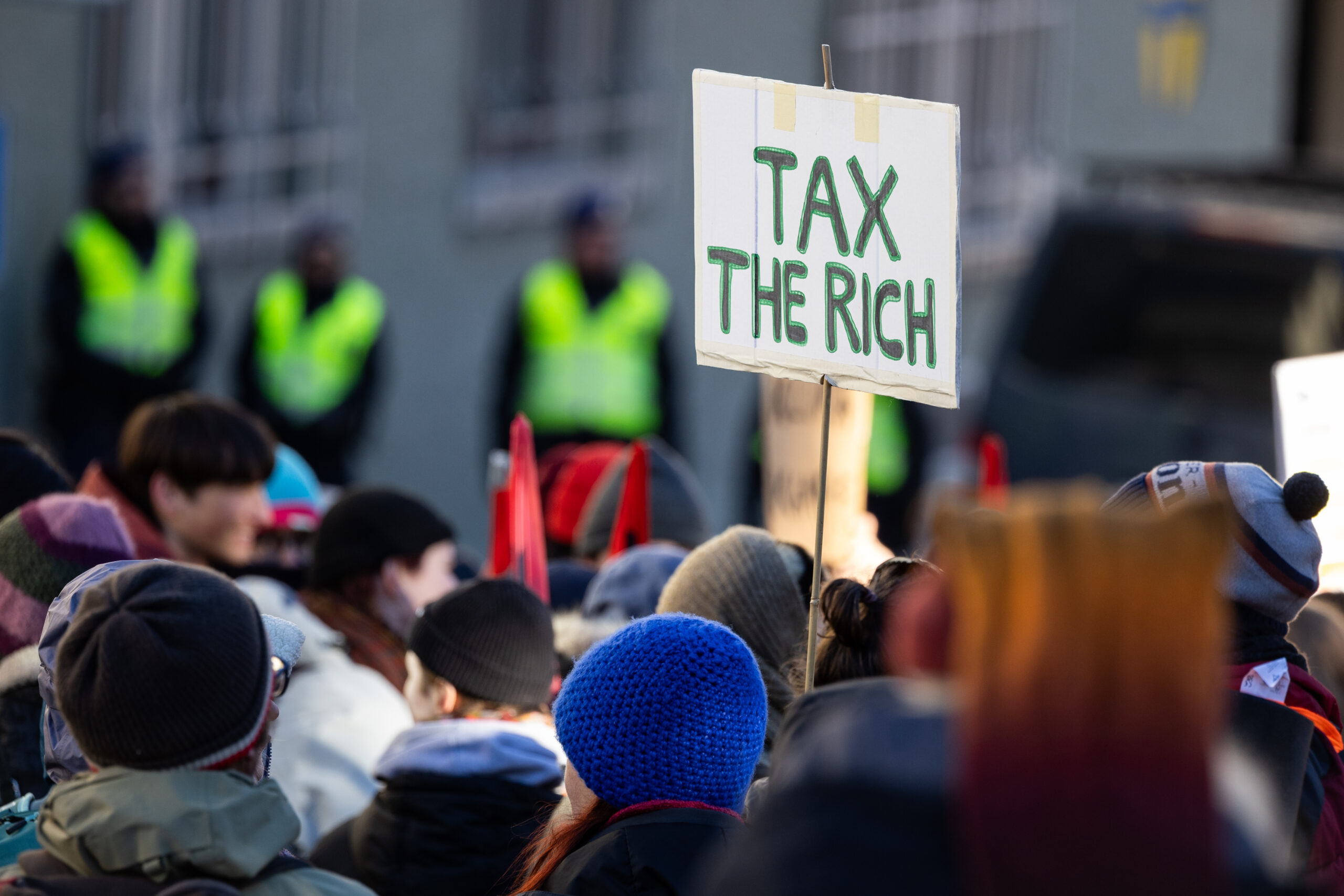 „Besteuert die Reichen” steht auf einem Plakat, den Demonstranten vor am Montag gestarteten dem Weltwirtschaftsforum in Davos hochhalten.