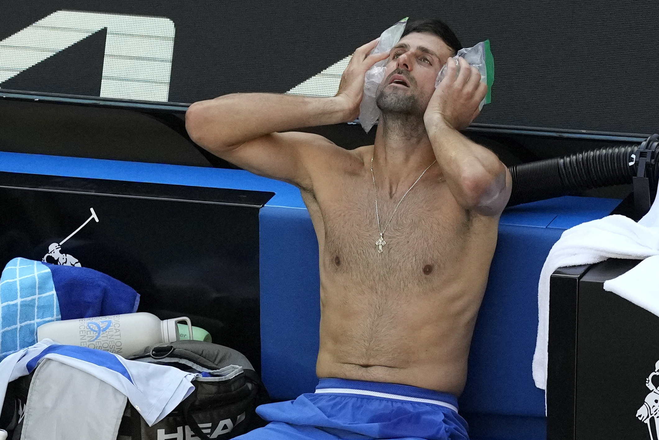Novak Djokovic hält sich zwei Eisbeutel an seine Wangen