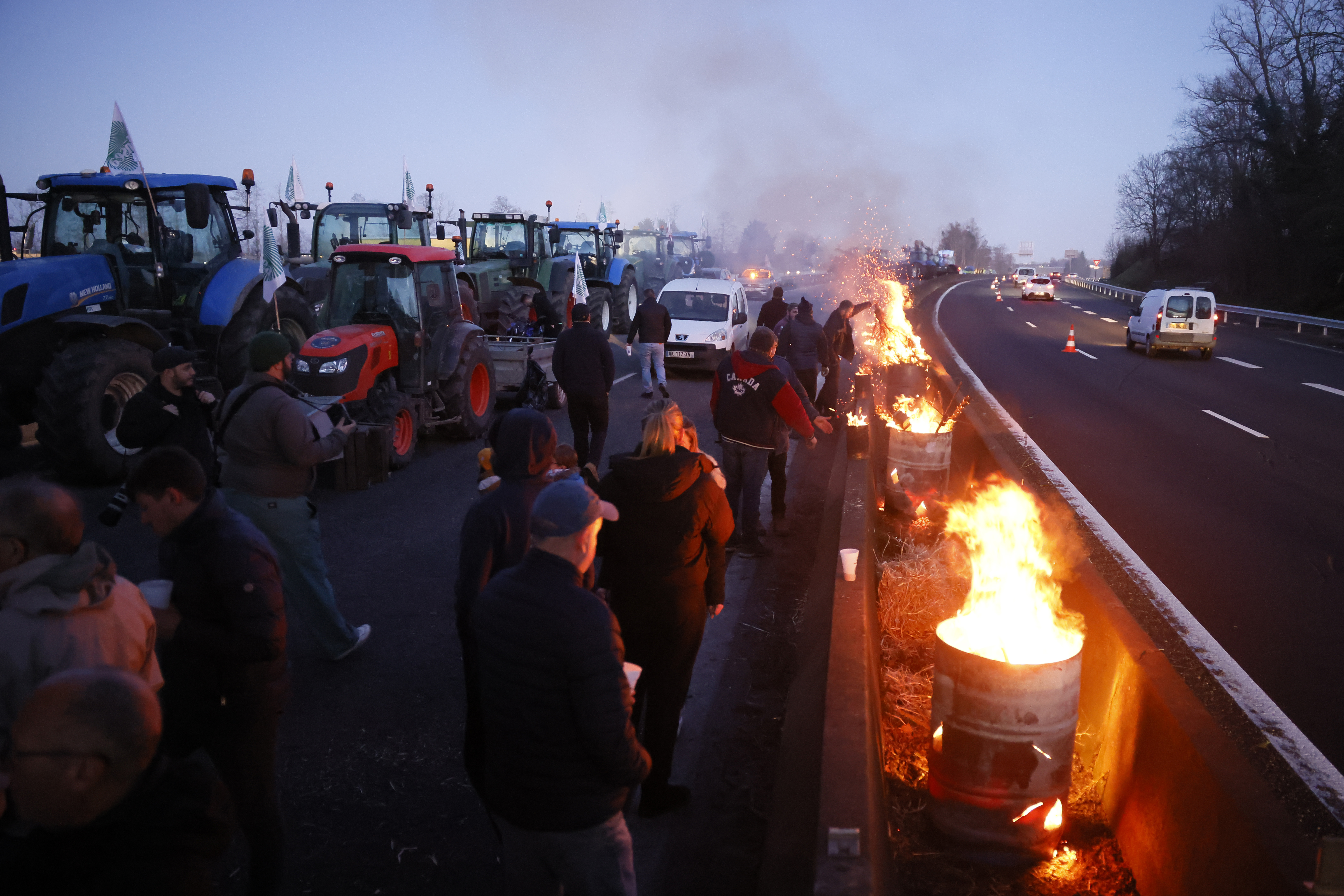 Traktoren und brennende Fässer auf einer Autobahn