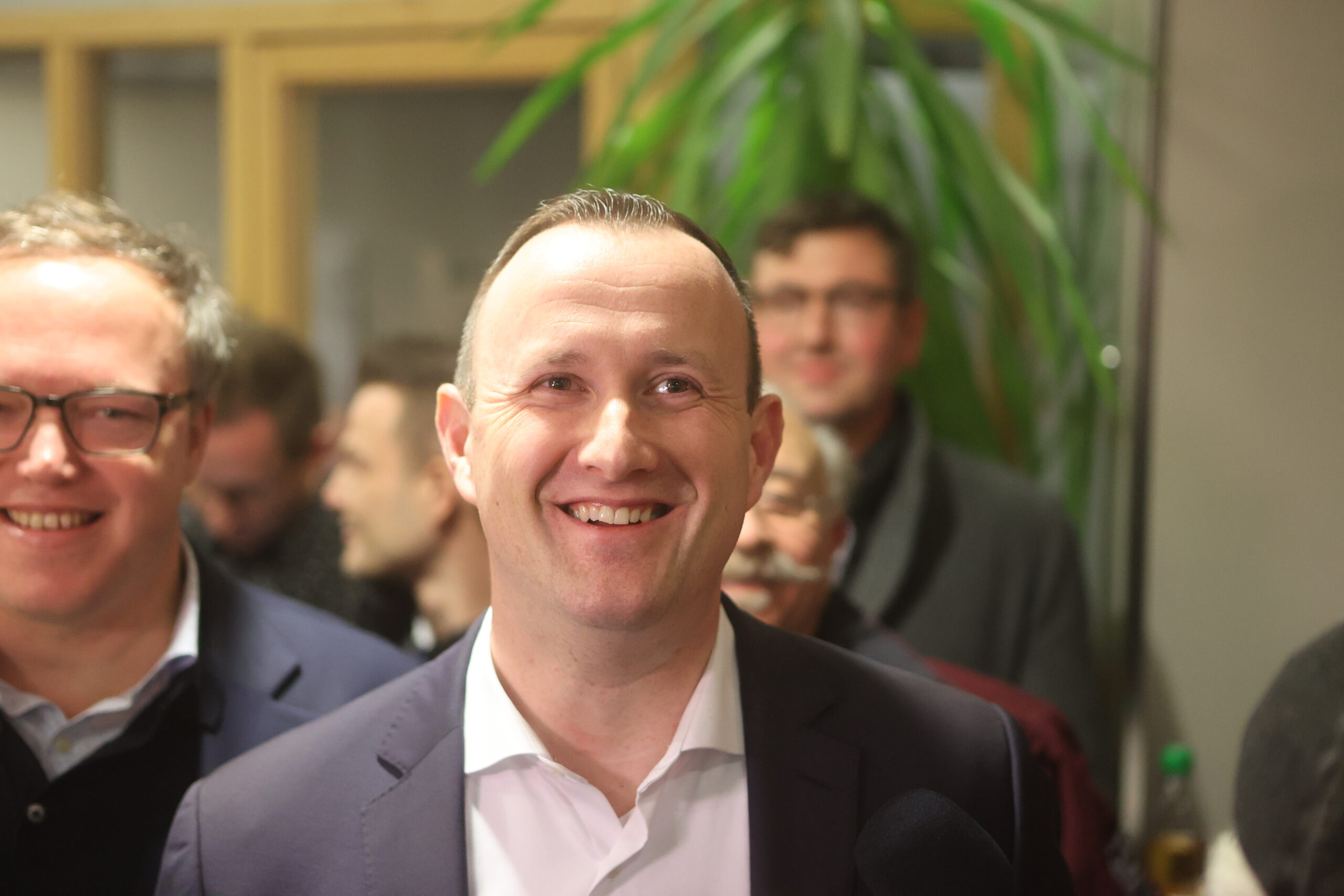 CDU-Kandidat Christian Herrgott steht lächelnd im Landratsamt und wartet auf die Bekanntgabe der Ergebnisse.