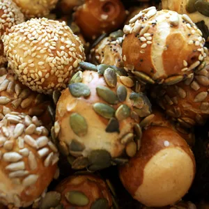 Kleine Brötchen mit verschiedenen Körnern bestreut liegen in einem Korb. (Archivbild)