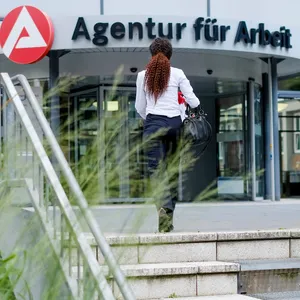 Eine Frau betritt eine Filiale der Agentur für Arbeit in Hamburg.