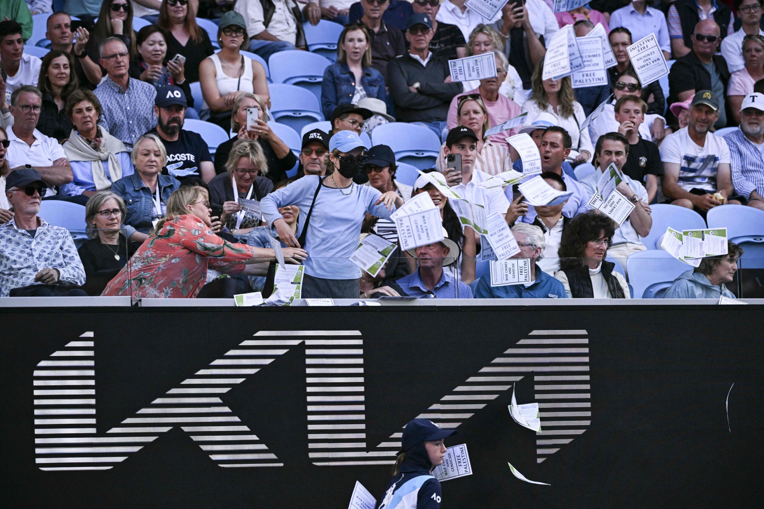 Eine Zuschauerin protestiert mit Flugblättern bei den Australian Open.