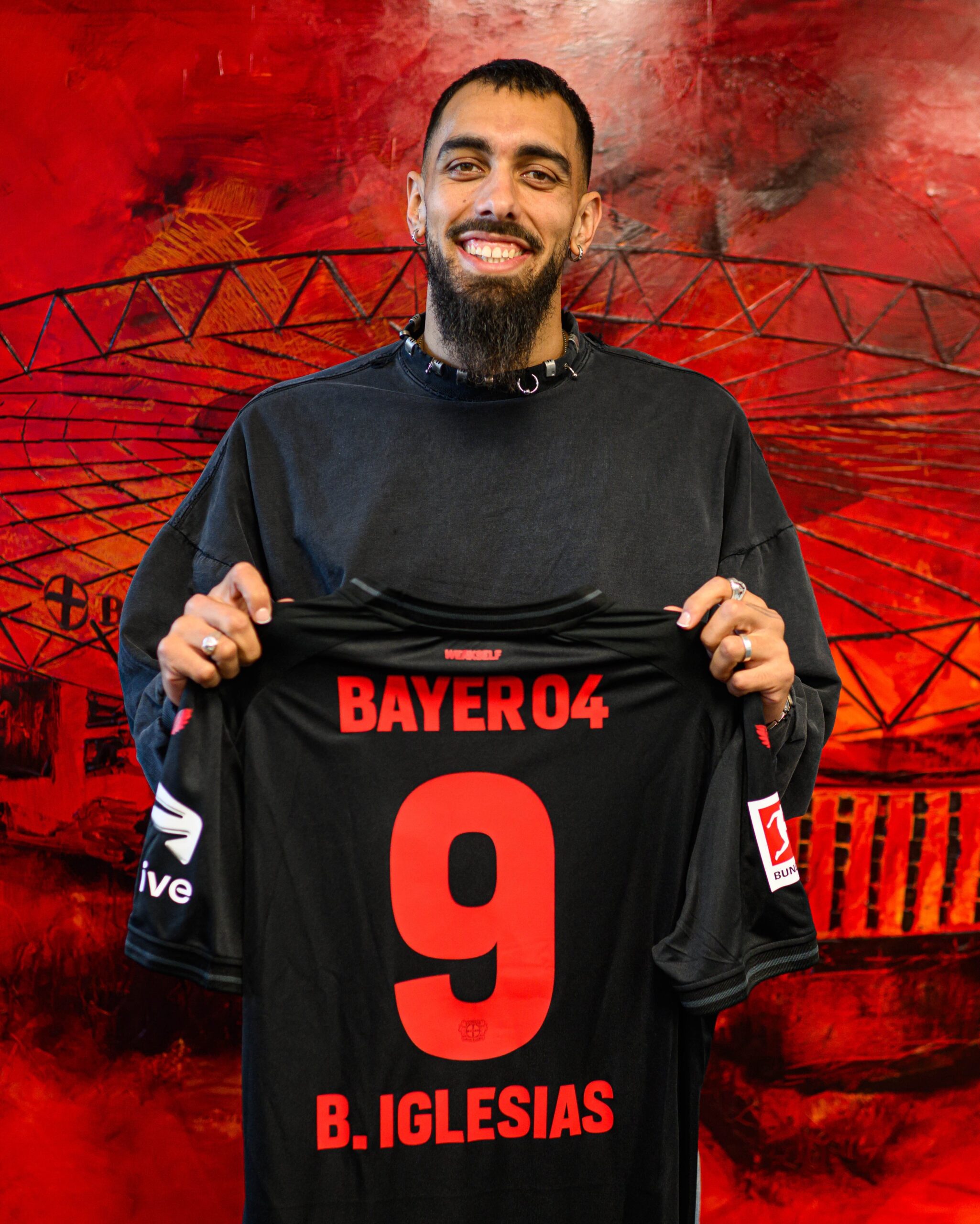 Borja Iglesias mit seinem Bayer 04 Leverkusen Trikot in der Hand.