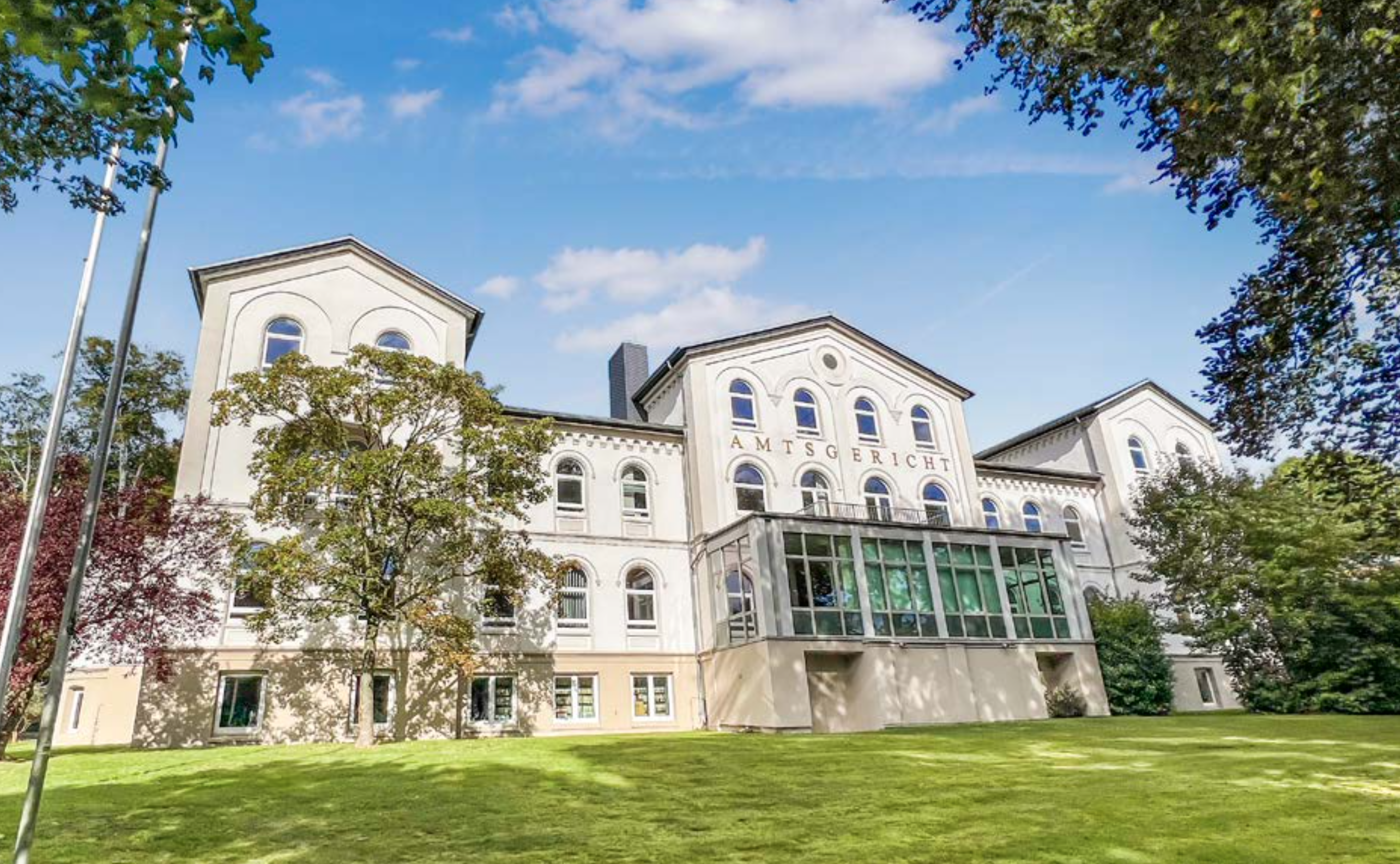 Das Amtsgericht Reinbek: ein großes Haus, weiß gestrichene Fassade, eine große Rasenfläche drumherum