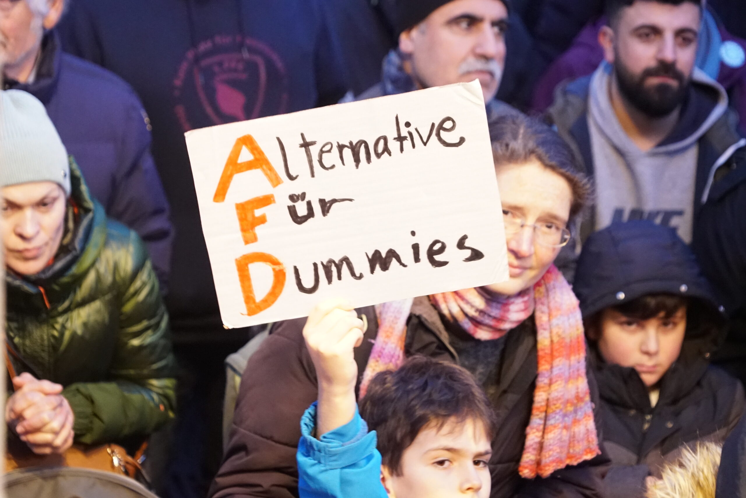 Kind hält Schild mit „Alternative für Dummies“ in die Luft