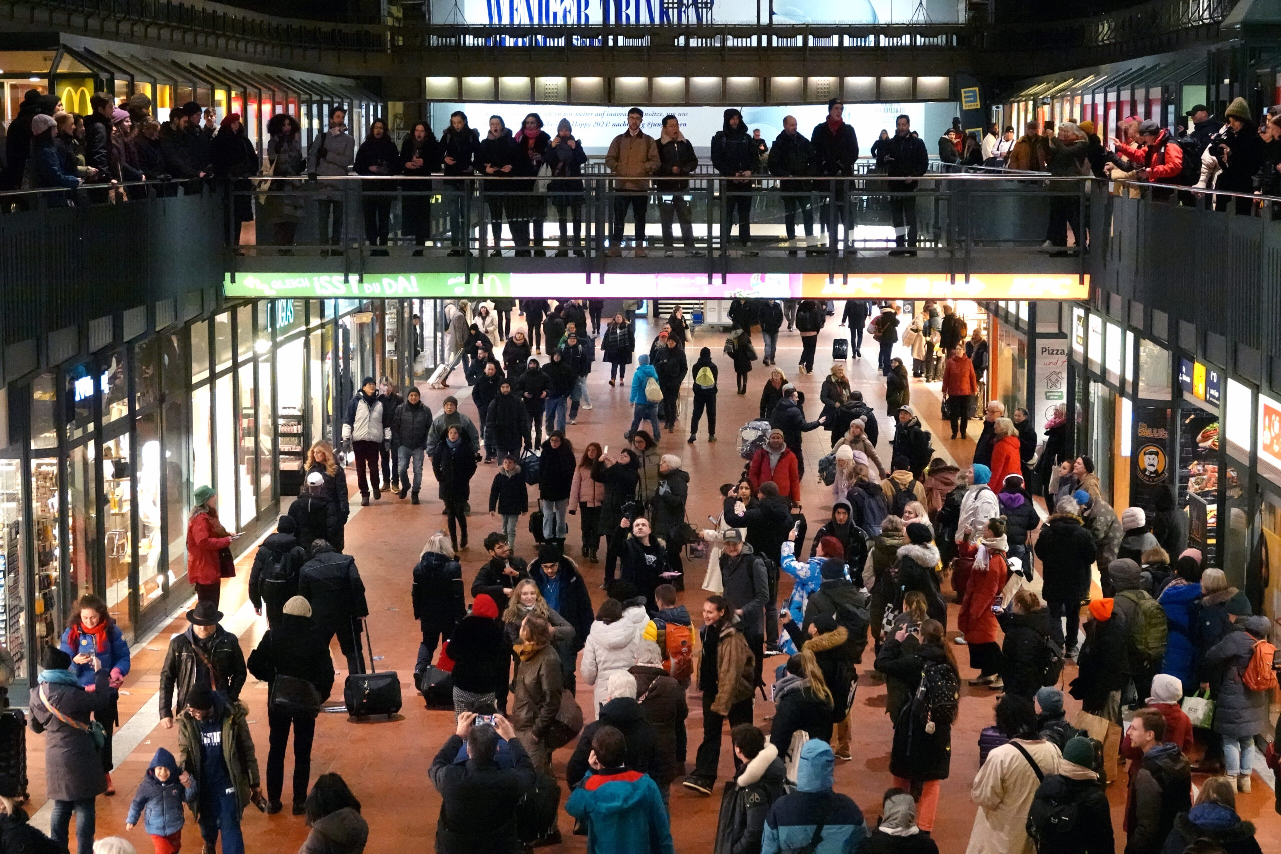 Sängerinnen und Sänger des „Aida“-Chores veranstalten auf der oberen Etage der Wandelhalle im Hauptbahnhof einen sogenannten Flashmob.