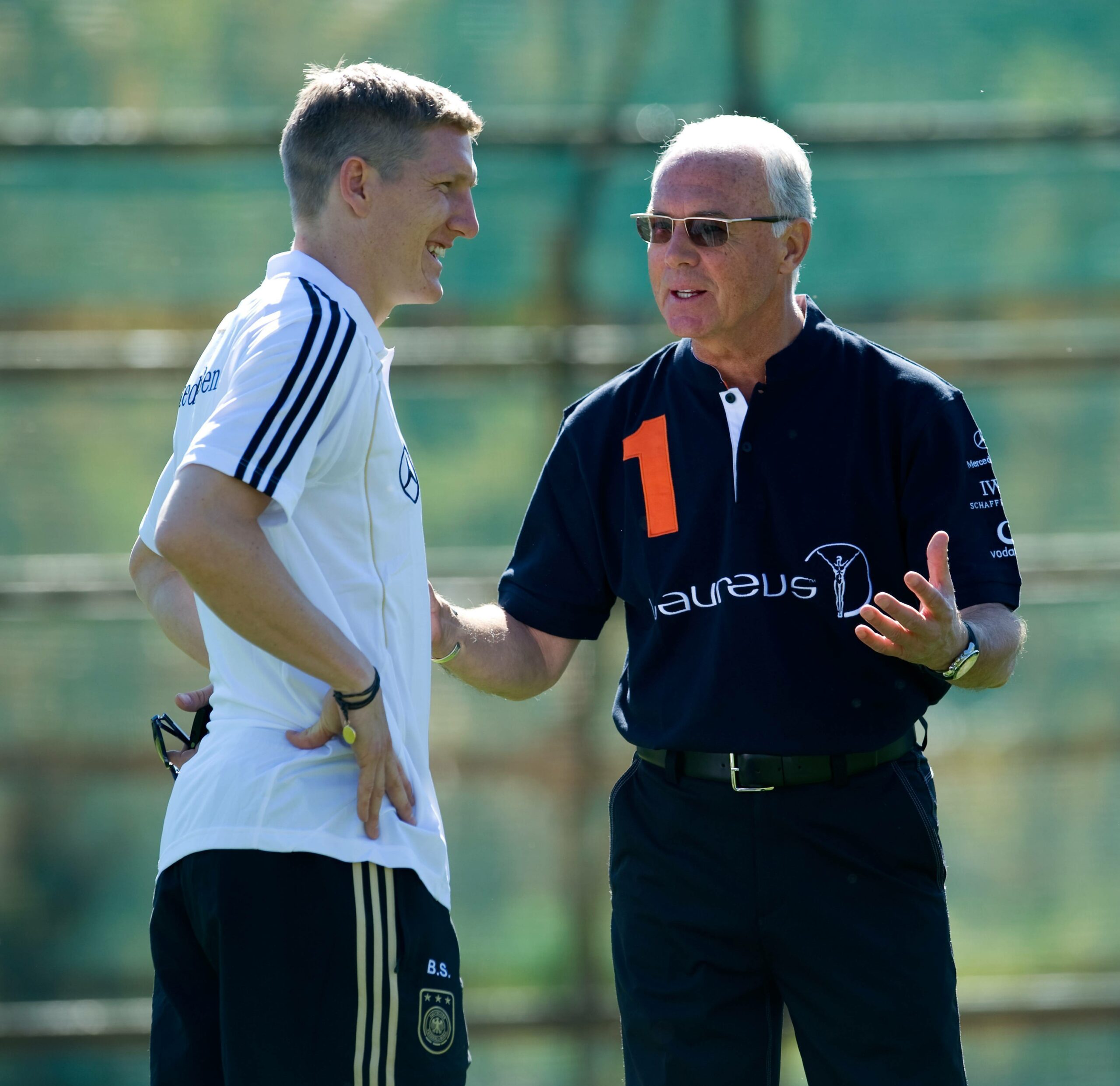 Bastian Schweinsteiger (l.) und Franz Beckenbauer unterhalten sich.
