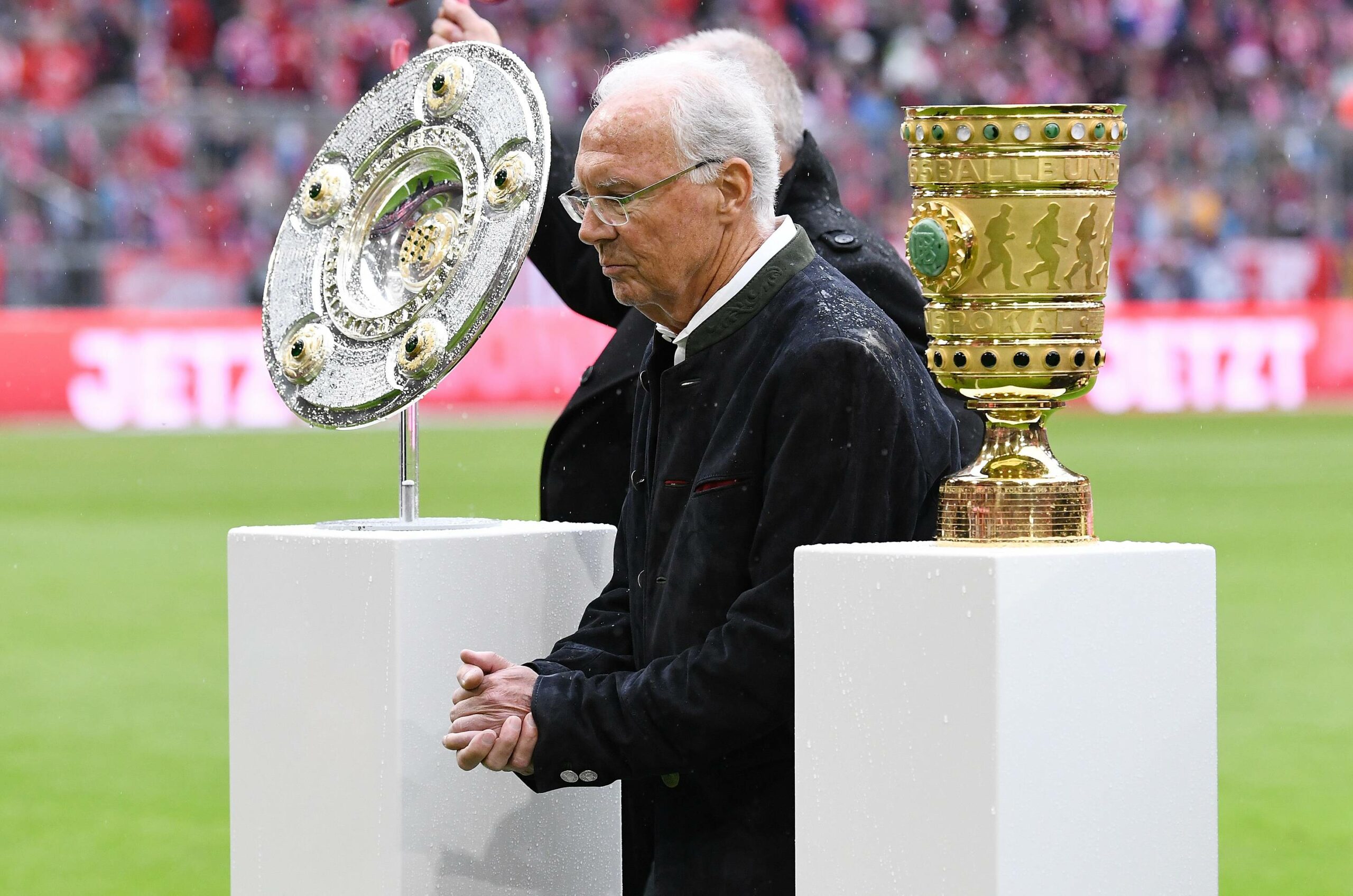 Franz Beckenbauer mit Meisterschale und DFB Pokal in der Allianz Arena