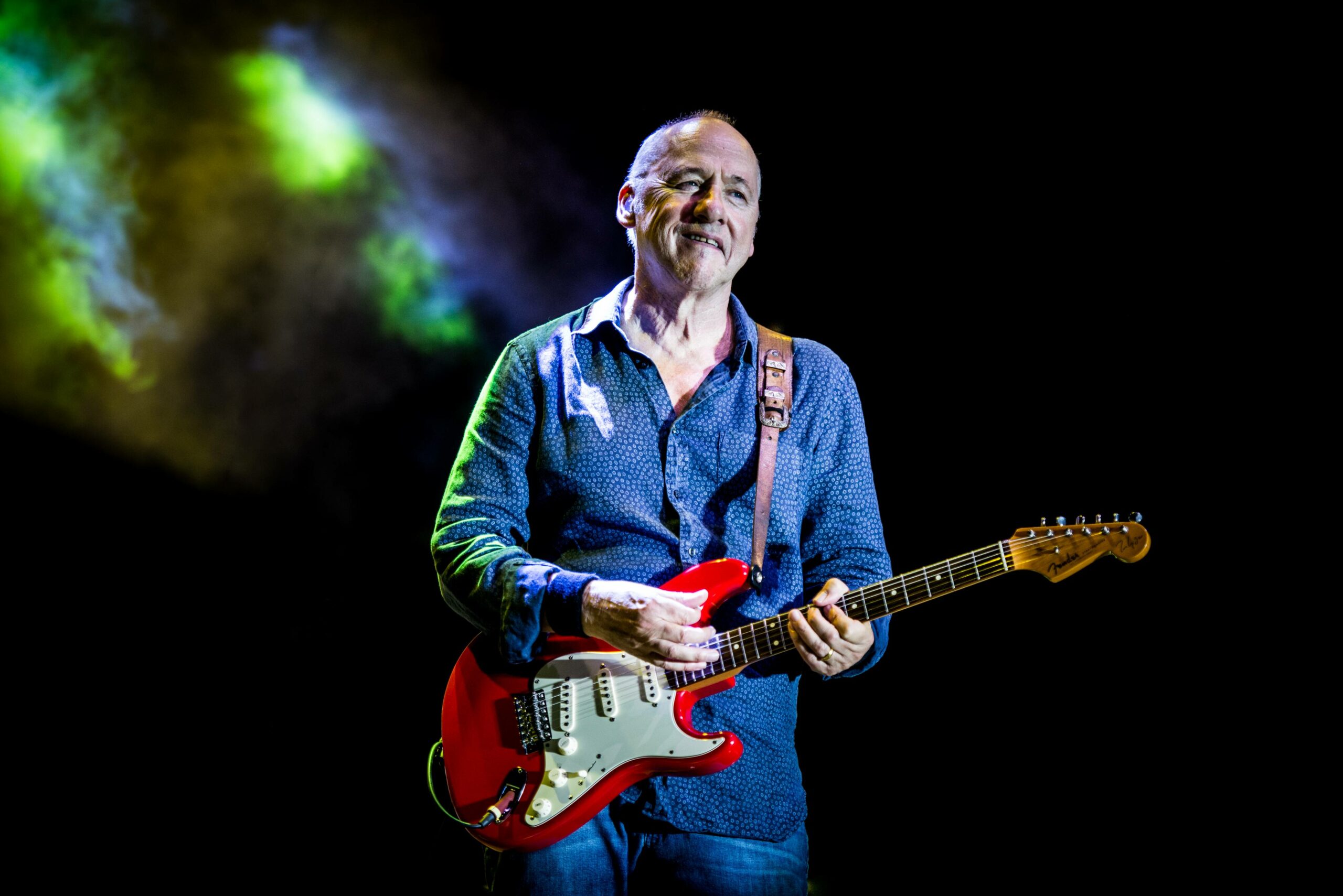 Mark Knopfler steht mit einer Gitarre bei einem Festivalauftritt in Italien auf der Bühne.