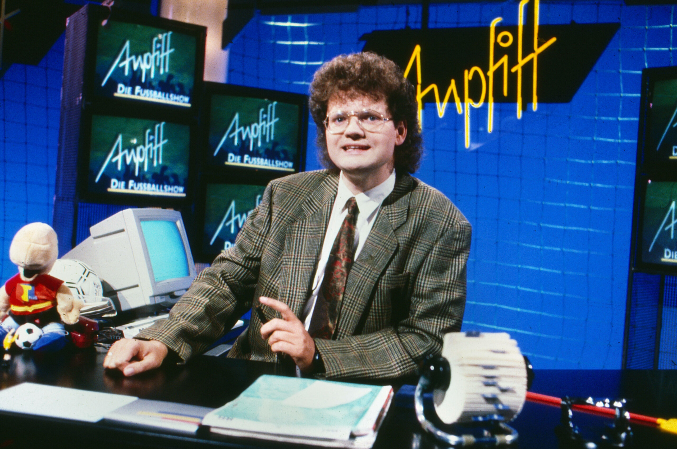 Ulli Potofski sitzt in der Kulisse der RTL plus-Fußball-Bundesliga-Sendung „Anpfiff“. Im Hintergrund stehen Bildschirme und ein Computer. (Archivbild von 1988)
