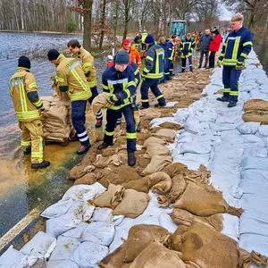 ilfskräfte beim Sandackstapeln auf der Zufahrt zum Serengeti-Park.