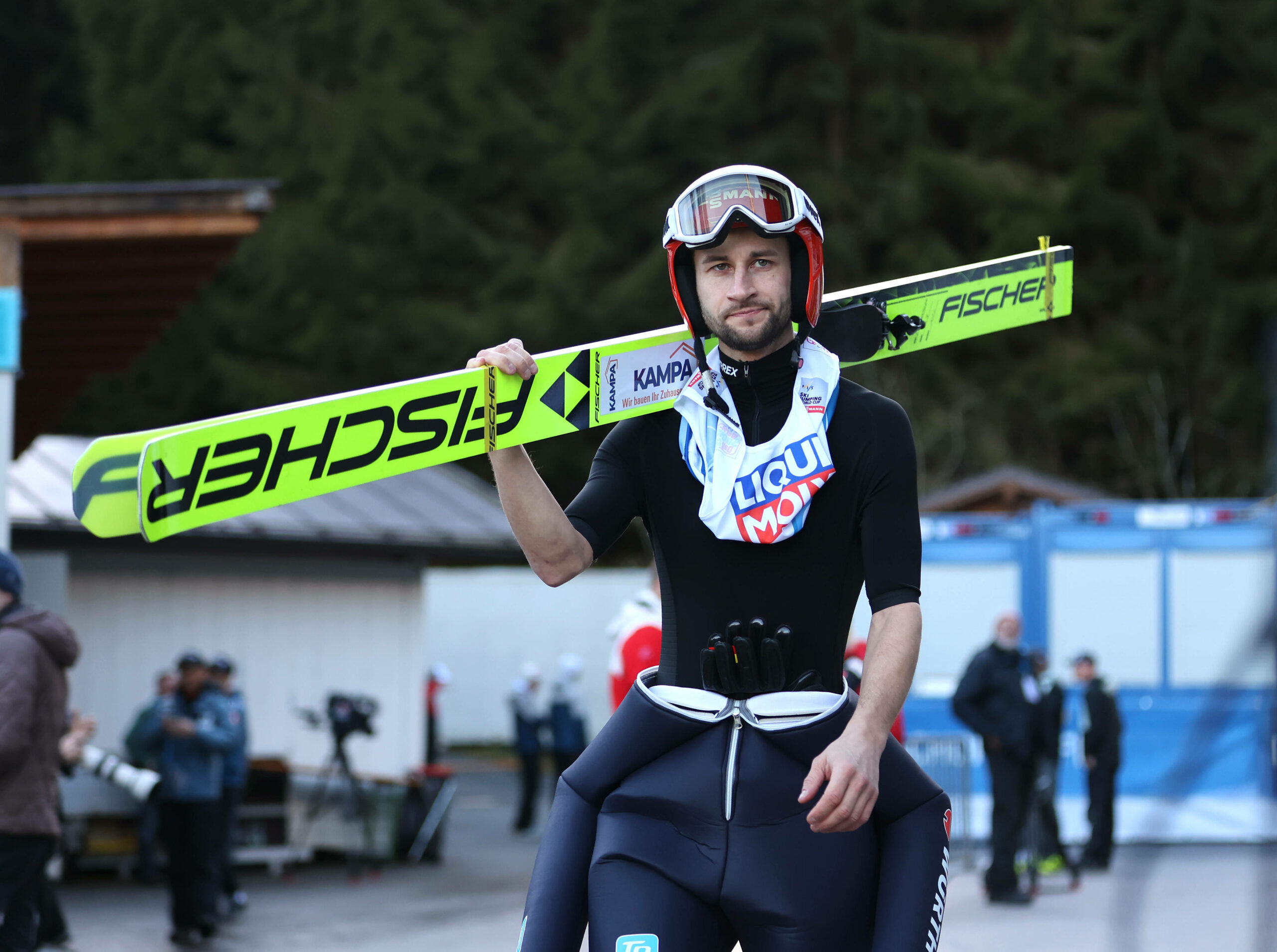 Markus Eisenbichler trägt seine Ski auf der Schulter und schaut frustriert