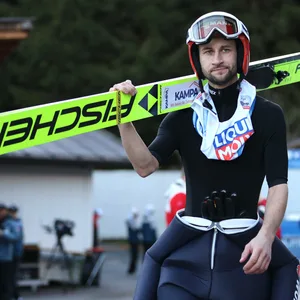 Markus Eisenbichler trägt seine Ski auf der Schulter und schaut frustriert