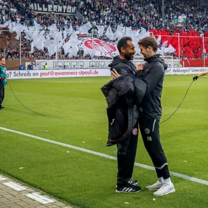 üsseldorf-Trainer Daniel Thioune und St. Pauli-Coach Fabian Hürzeler klatschen sich ab