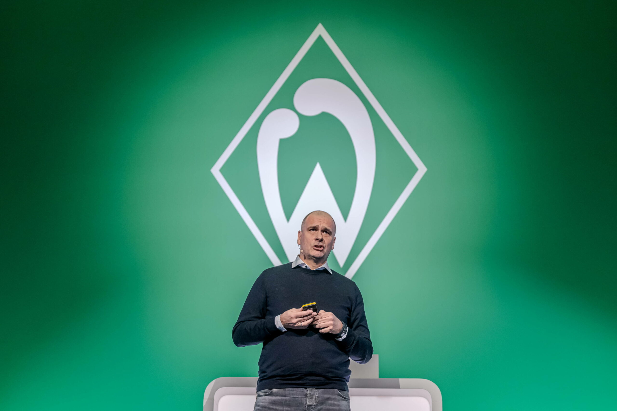 Klaus Filbry vor einem Werder-Logo