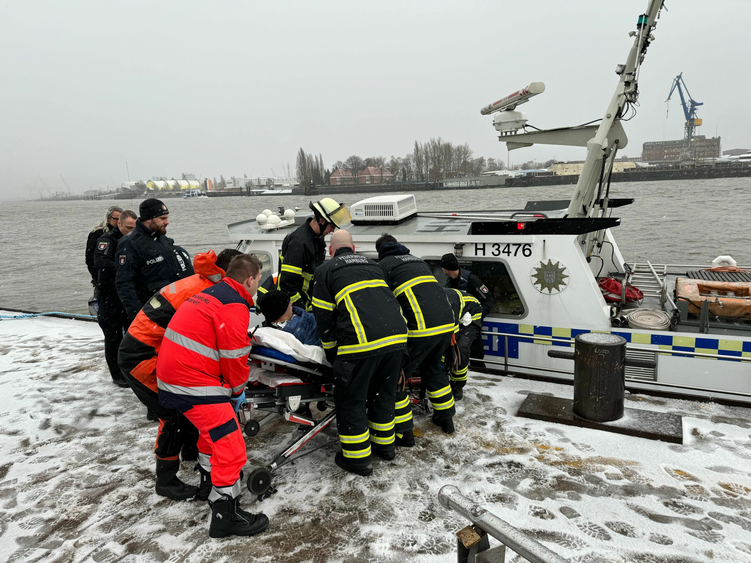 Einsatzkräfte kümmern sich um den in die Elbe gefallenen Mann