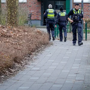 Polizisten vor dem Wohnhaus in Bergedorf.